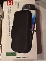 Front of retail box displaying black hard EVA travel case for N-S