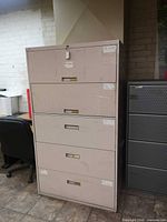 Front view of closed five-drawer beige metal lateral cabinet