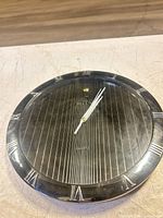 Front view of Bell's wall clock showing bezel, dial, hands