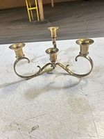Full view of brass candelabra showing three arms and cups