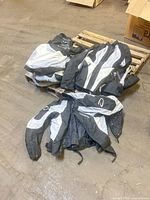 Pile of black/gray Daymak motorcycle jackets on pallet