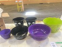 Assorted plastic Halloween bowls and buckets displayed together