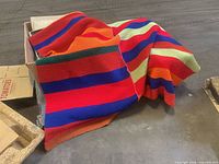 Overall view of multicolor striped blanket draped over box