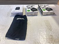 One unpackaged black dog shirt with iBitch. print, three retail boxes visible