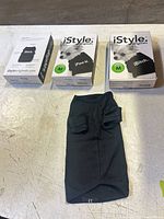 Three retail boxes and one unboxed black dog shirt displayed