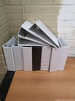 Front view of seven upright binders with three stacked on top