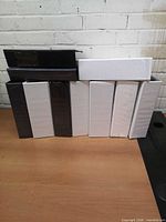 Front view of eight binders standing upright plus two stacked, showing colour distribution and spine widths