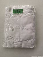 Front of packaged white compression tank top displaying size sticker