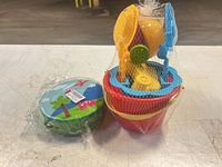Sand toy set and drum packaged together on table