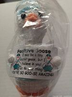 Goose figurine sealed in plastic displaying sign