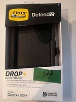 Front of boxed OtterBox Defender case showing product name and phone compatibility