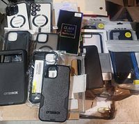 Group shot of OtterBox cases, generic cases, and glass protector boxes laid out