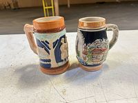 Front view of both beer steins showing designs and colors