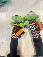 Two identical Multipet Halloween plush dog toys with tags