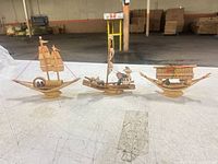 Front view of all three bamboo miniature boats on table
