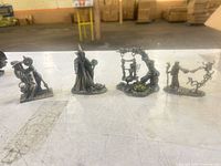 Front view of all four pewter fantasy figurines on table