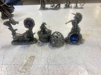 Front view of all four pewter figurines showing size relation and crystal accents