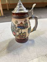 Front view of ceramic mini beer stein showing Luzern relief, handle, and pewter lid