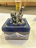 Wizard and dragon figurine on top of Tudor Mint box