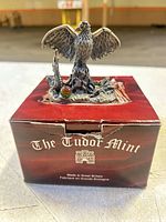 Figurine positioned on Tudor Mint box front view