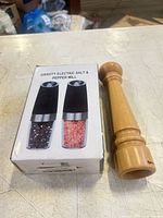 Boxed electric gravity mills beside wooden pepper mill