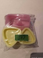 Sealed package showing pink rectangular mold and two yellow triangular molds