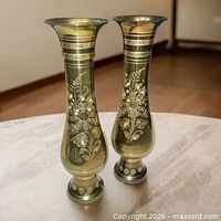 Front view of both brass vases showing etched floral design