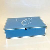 Top view of powder blue glass box showing white initial C