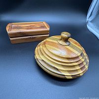 Round segmented trinket box and rectangular hinged box side by side