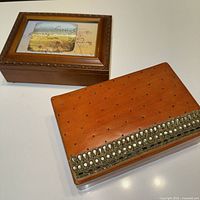 Both boxes: wood-tone musical box and beaded leather box side by side
