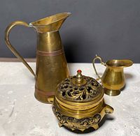 Group shot of all three vessels: tall copper-banded pitcher, small creamer, round pierced incense burner