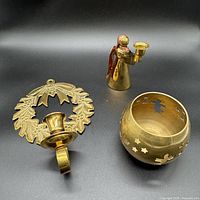 All three brass candle holders grouped