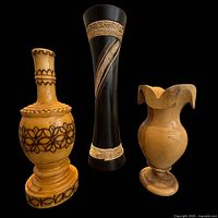 Front view of three wooden vases showing size, color, and decorative details