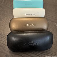 Four stacked closed cases showing brand names