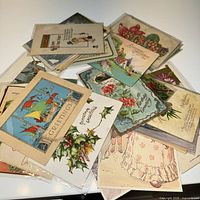 Pile of antique greeting postcards showing various designs