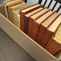 Box of mixed antique books showing encyclopedias and assorted softcovers