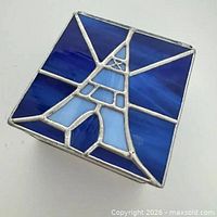 Top view showing Eiffel Tower design and two-tone blue glass lid