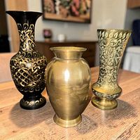 Group shot of three brass vases on tabletop