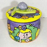 Front view showing lid with bone handle, knob and art