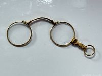 Lorgnette unfolded showing both circular frames and hinged bridge