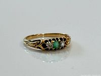 Top view showing emerald and two diamonds in gold setting