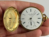Dial and inner cover of open watch showing porcelain face, Roman numerals, sub-seconds, edge chip, key-wind arbor
