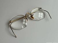 Front angled view showing rimless octagonal lenses and gold bridge