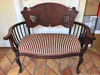 Front view of mahogany settee showing overall design and striped upholstered seat