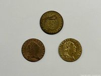 Obverse and reverse of three brass King George III gaming tokens