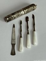 all items laid out: engraved case, nail file, three tools