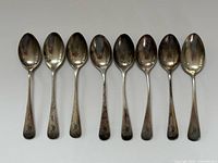 Eight sterling demitasse spoons laid out
