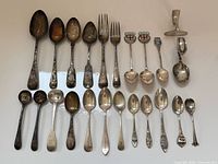 Full layout of 23 sterling flatware pieces