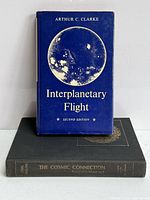 Front view of both books showing Clarke book upright with dust jacket and Sagan book flat