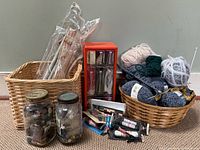 Group shot showing baskets with needles, yarn balls, jars of buttons, organizer, shoelace packages